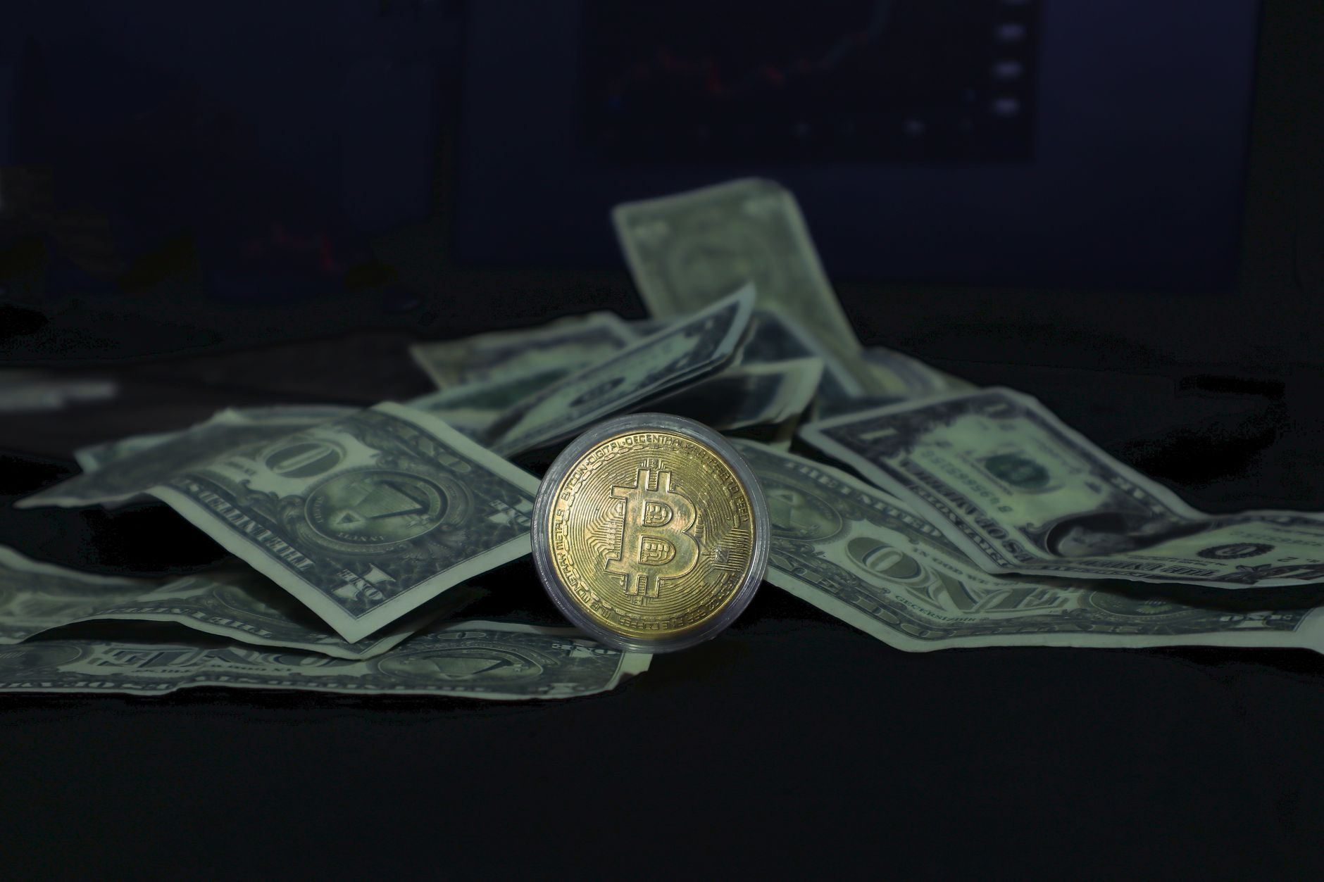 Close-up of a Bitcoin coin and US dollar bills, highlighting cryptocurrency and finance.