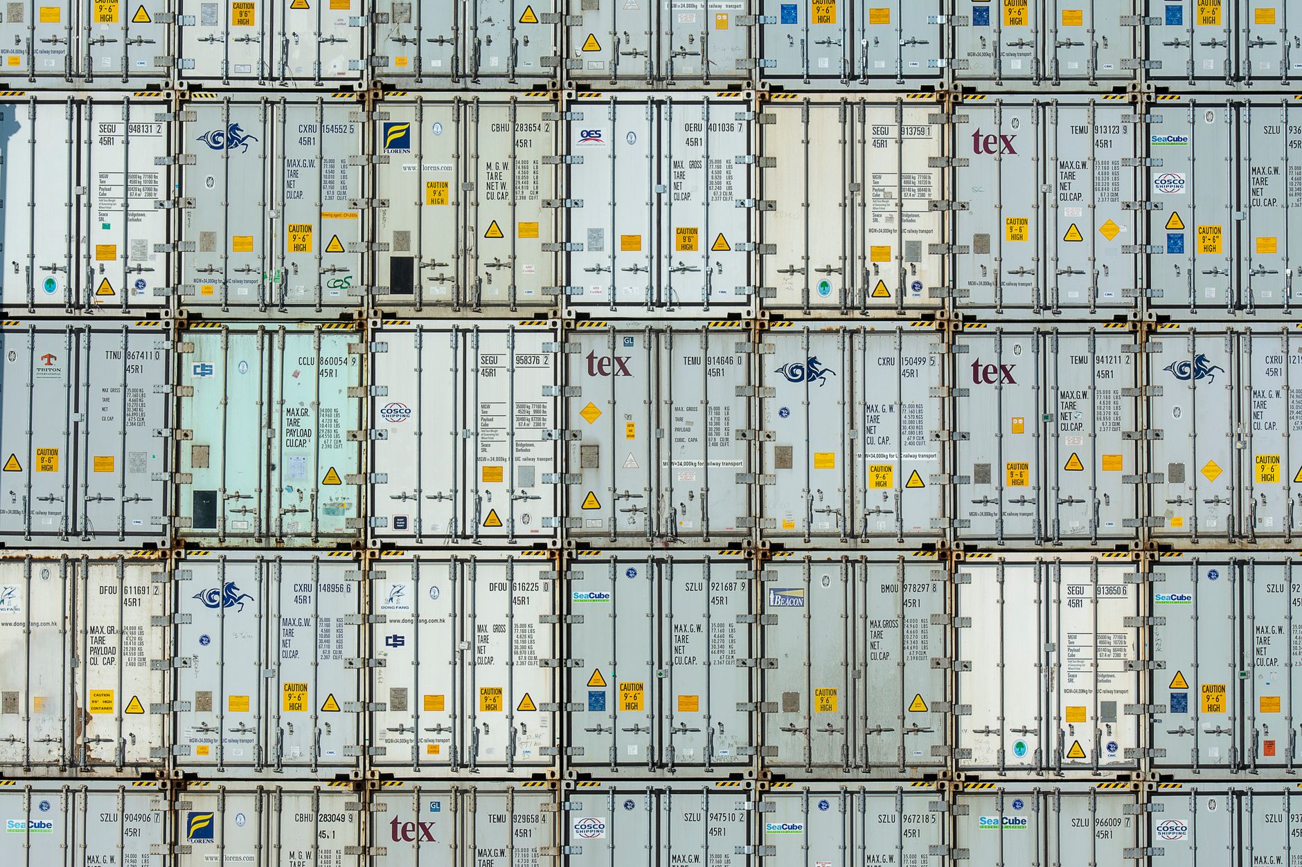 A patterned array of industrial shipping containers stacked in a storage terminal.