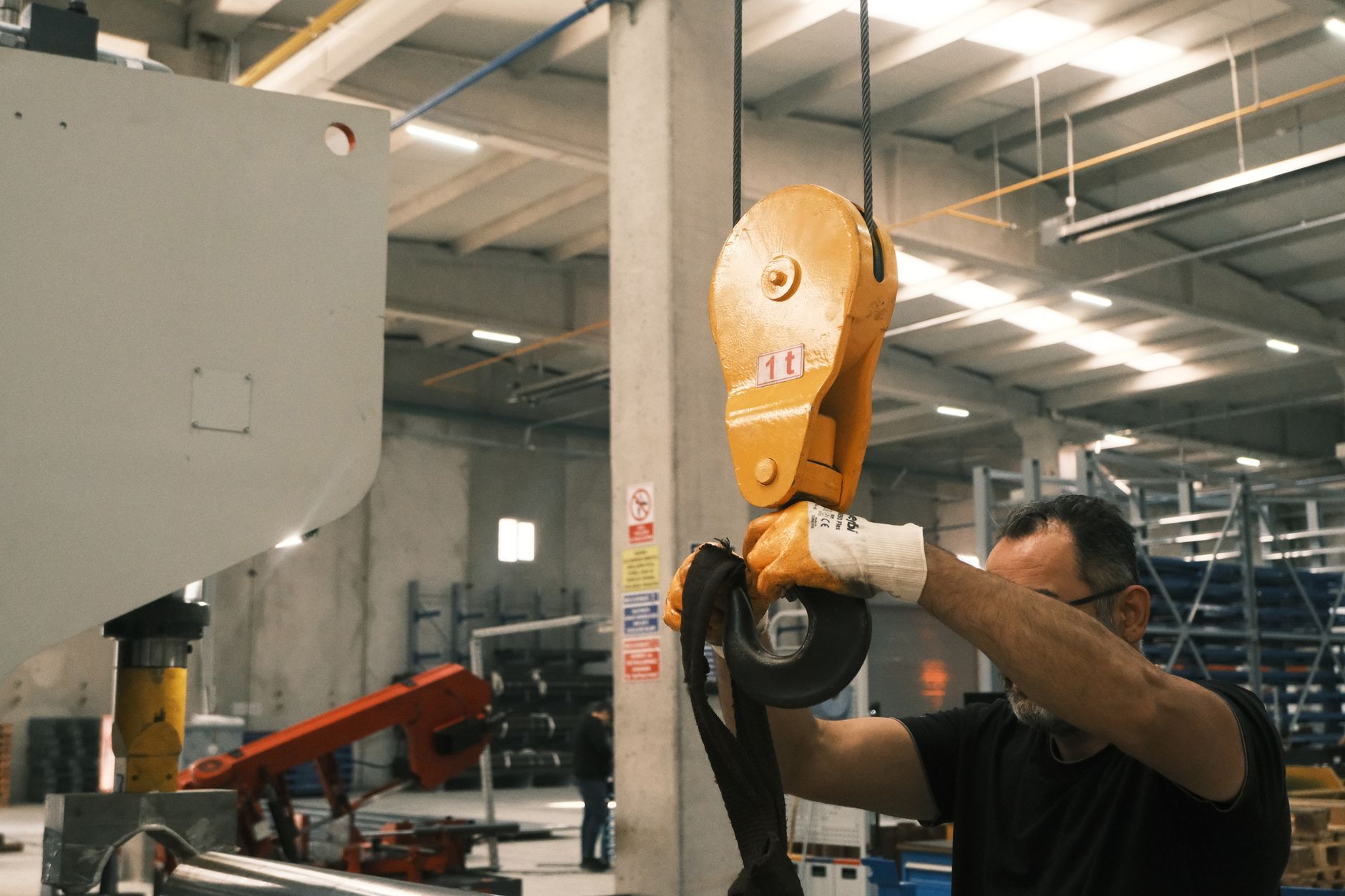 A worker operates industrial lifting machinery in a Konya factory setting.