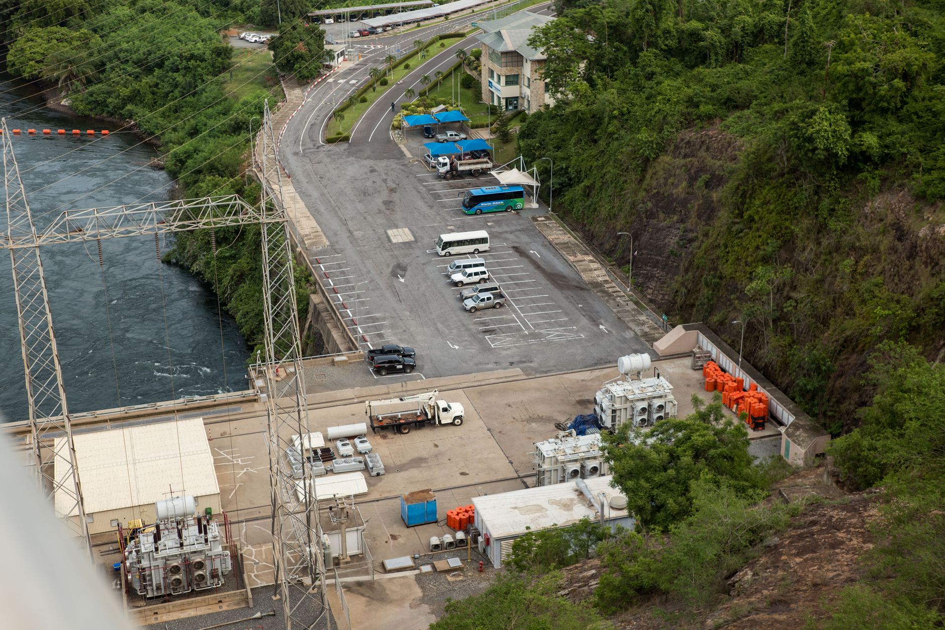 Aerial shot of a hydroelectric plant surrounded by lush greenery and water.
