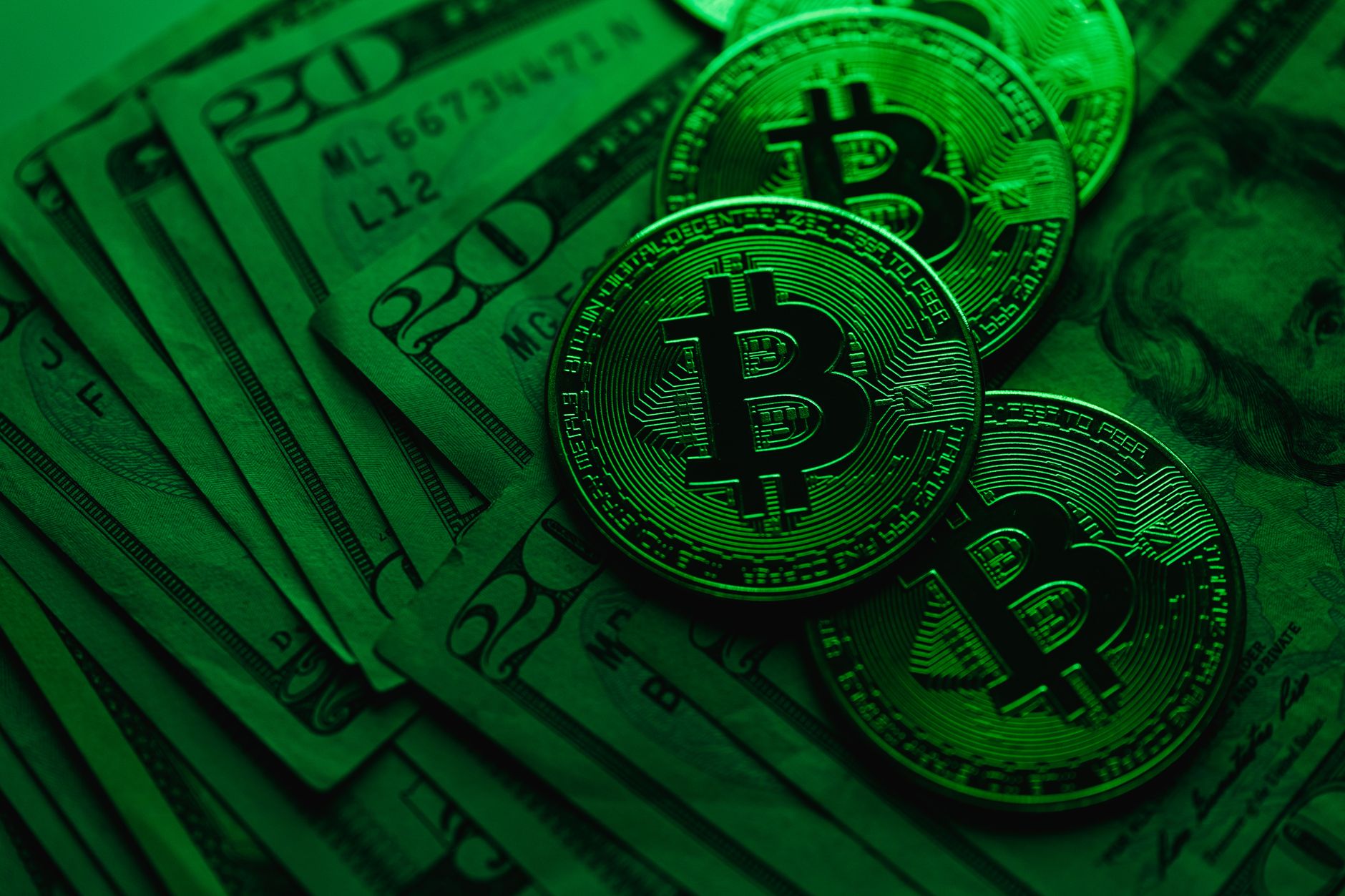 Close-up of Bitcoin coins on US dollar bills, showcasing cryptocurrency's value.