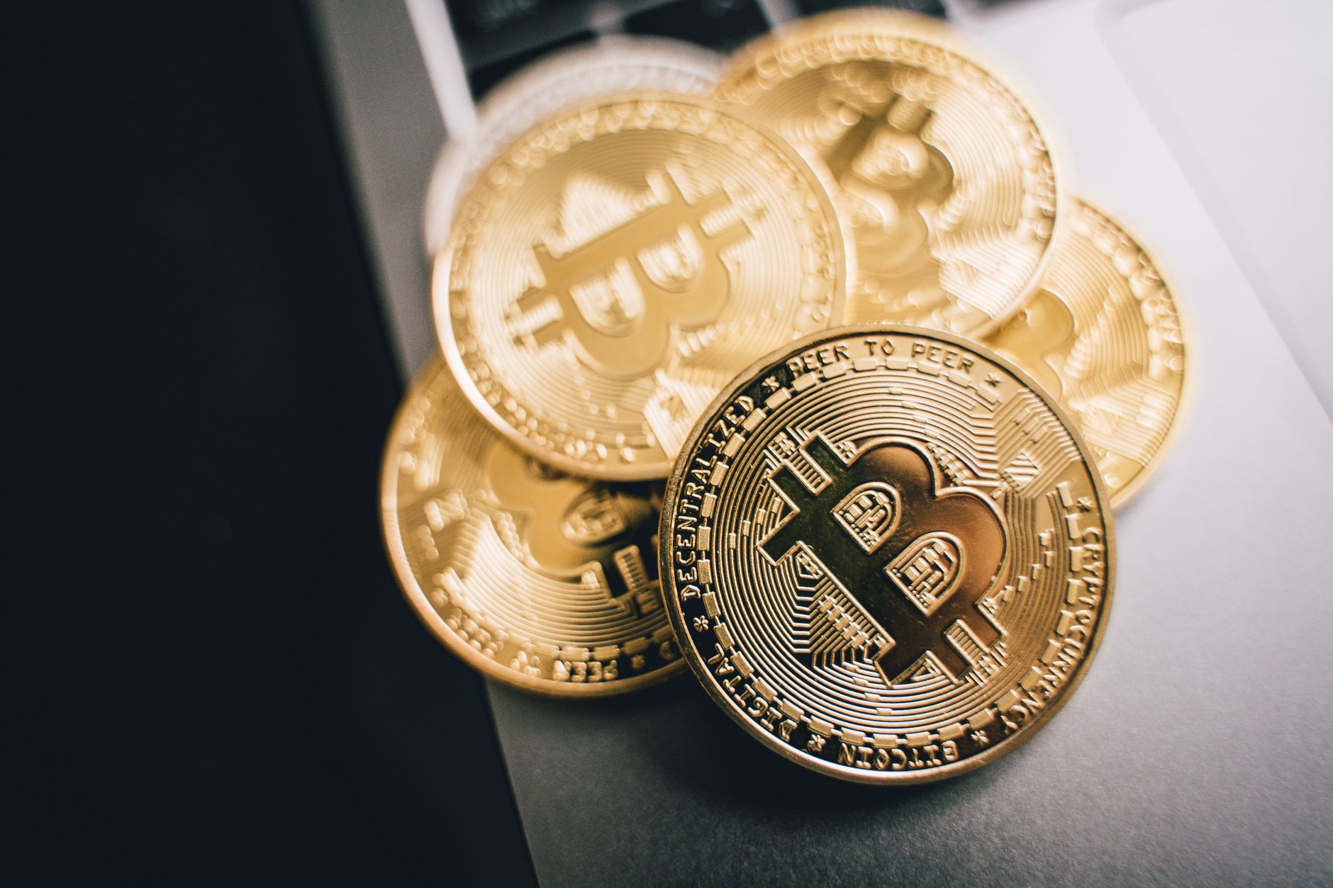 Close-up of golden Bitcoin coins on a laptop keyboard, symbolizing cryptocurrency investment.