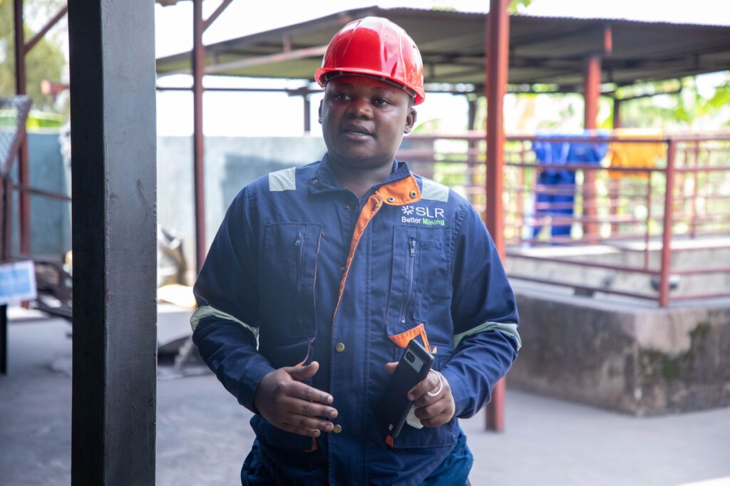A mining engineer in safety gear stands confidently at an industrial site, showcasing modern safety standards.