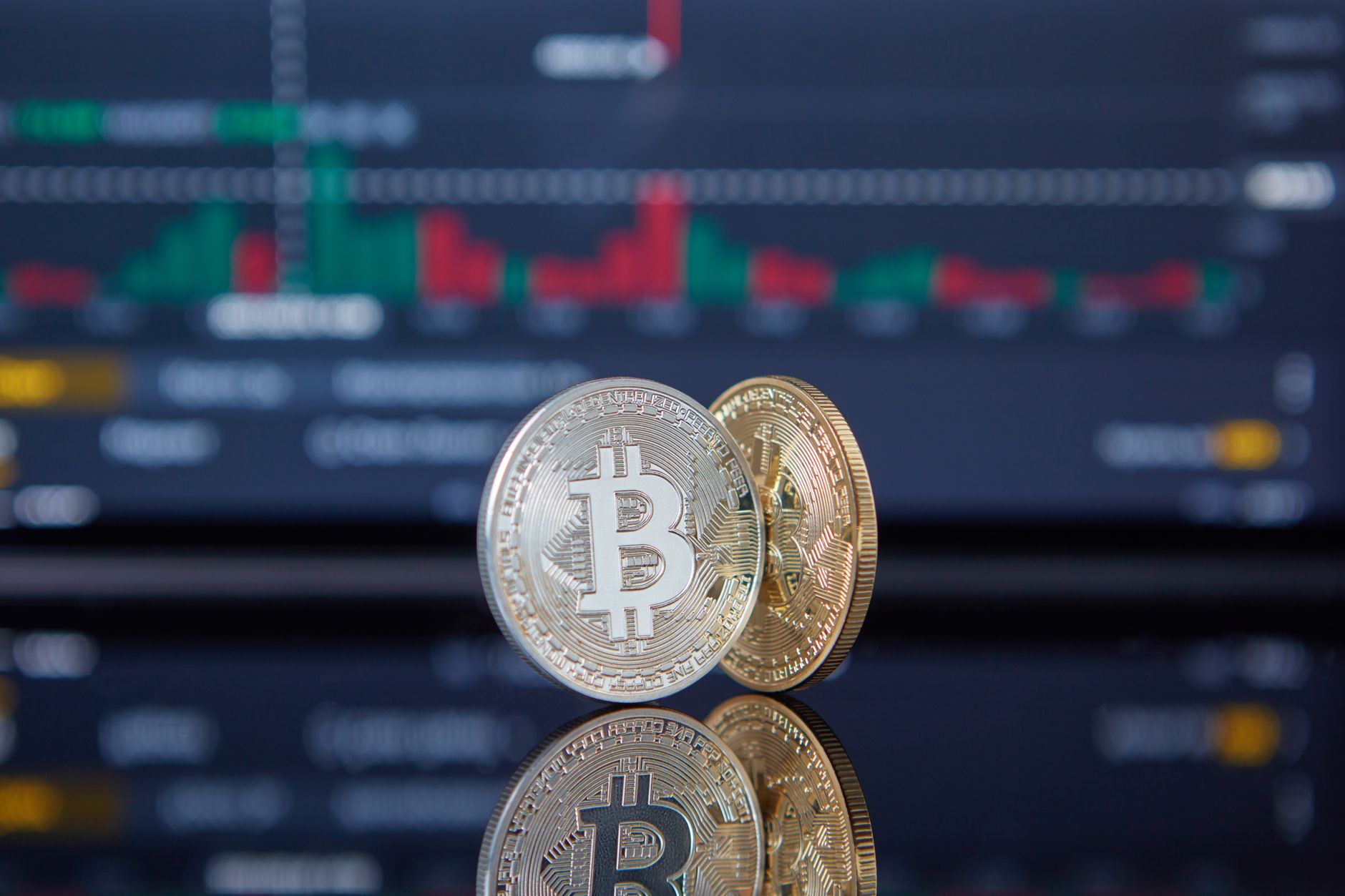 Bitcoin coins with a stock market background representing cryptocurrency and trading.