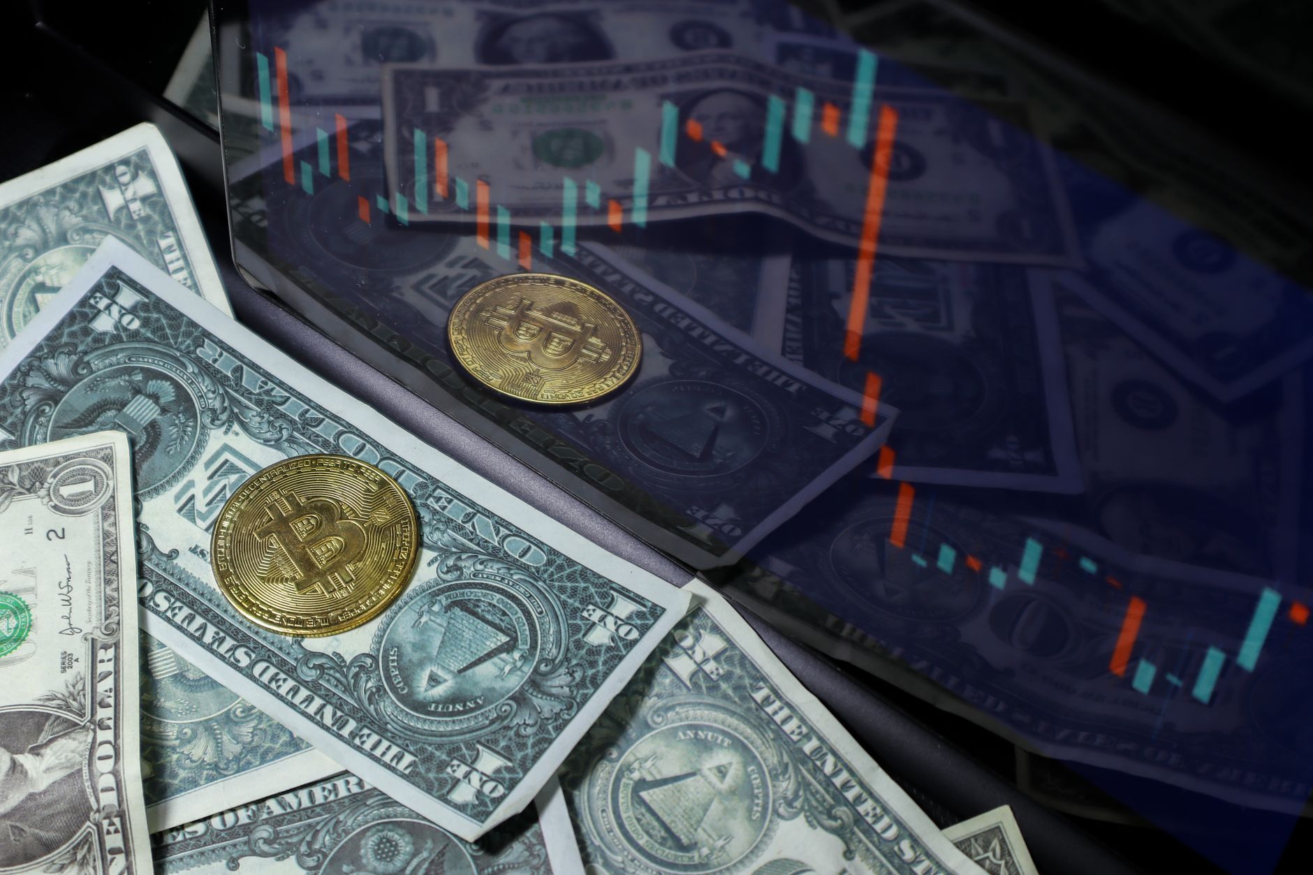 Bitcoin coin on US dollar bills with a stock market chart background. Represents cryptocurrency and finance.