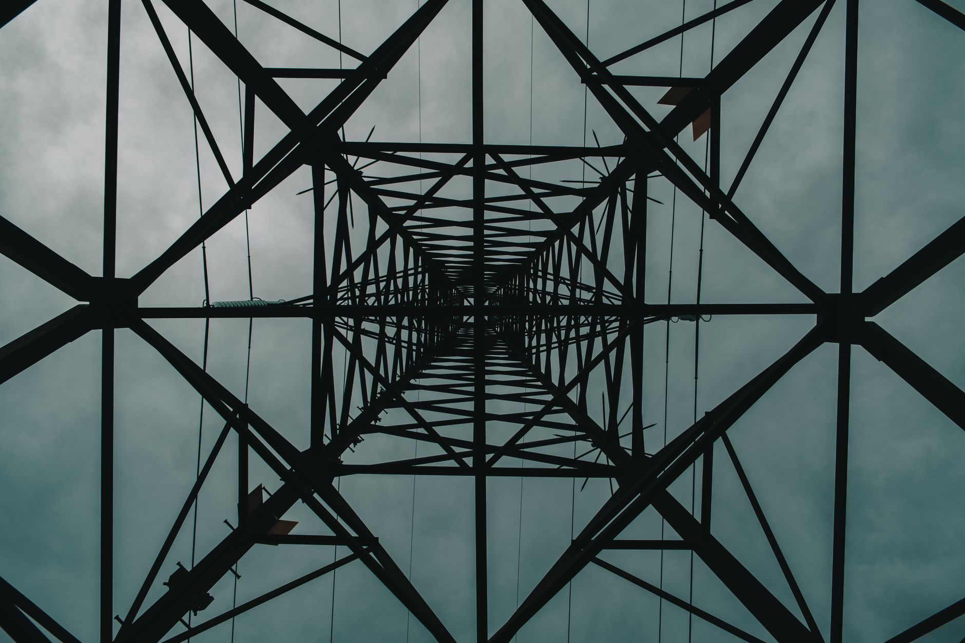 Low angle view of a tall steel structure under a cloudy sky, creating a dramatic, moody atmosphere.
