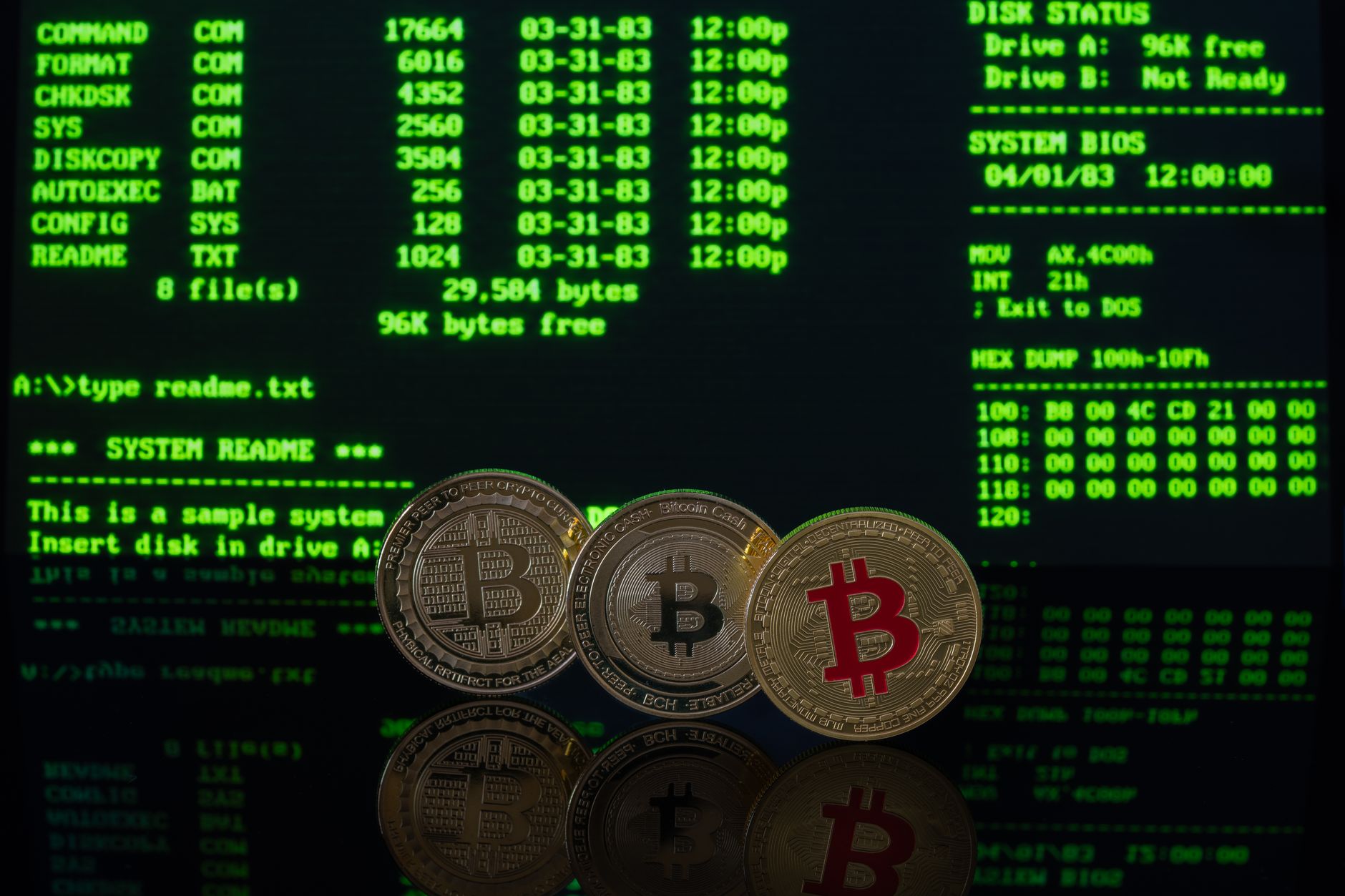 Bitcoin coins in front of a vintage computer screen displaying DOS commands, symbolizing digital currency.